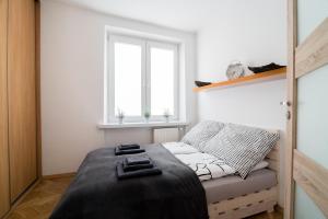 a bed in a room with a window at THE HEART OF NOWA HUTA - free garage in Krakow