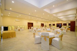 salę bankietową z białymi stołami i białymi krzesłami w obiekcie Lilypool - The Heritage Jalmahal w mieście Dżajpur