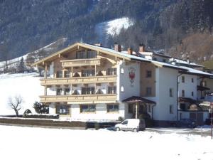ein großes Gebäude mit einem davor geparkt in der Unterkunft Landhaus Tirol in Zellberg