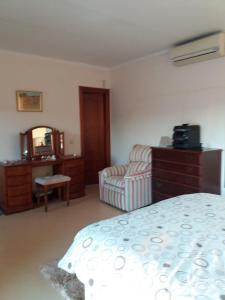 a bedroom with a bed and a chair and a mirror at Villa de La Rosa in Málaga