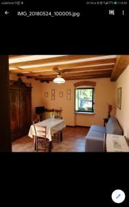 a living room with a table and a couch at Guest House " IL FARINELLO " in Garessio