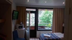 Zimmer mit Fenster, Bett und TV in der Unterkunft Sea Hotel Mäntyniemi in Siltakylä