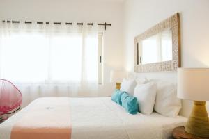a bedroom with a bed with a mirror and two lamps at Fabiola Condo Hotel in Playa del Carmen