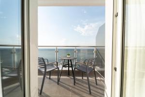 einen Balkon mit einem Tisch und Stühlen sowie Meerblick in der Unterkunft Atlantis ''Pleasure by the Sea'' in Peraia