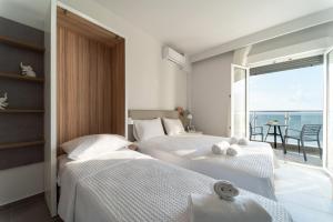 2 łóżka w sypialni z widokiem na ocean w obiekcie Atlantis ''Pleasure by the Sea'' w mieście Perea