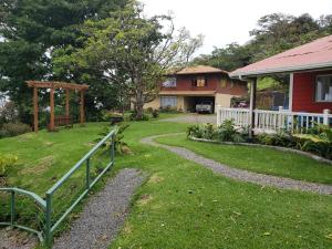 una casa con una valla delante de un patio en Casa El Granero Monteverde, en Monteverde