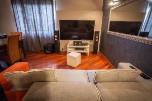 un salon avec un canapé et une télévision à écran plat dans l'établissement Cinematic Modern Flat, 100 mt da Ospedale, à Ravenne