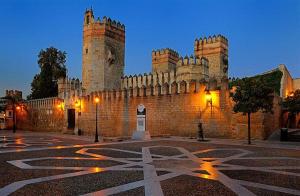 a large castle building with a clock tower at night at ATICO SAN MARCOS in El Puerto de Santa María