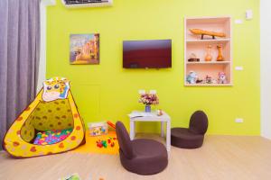 a childs play room with a tv on a green wall at 曉翠軒親子民宿 in Wujie