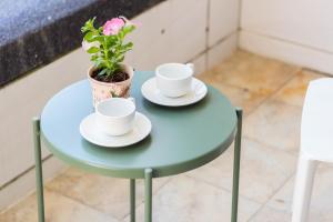 a table with two cups and a potted plant on it at 曉翠軒親子民宿 in Wujie