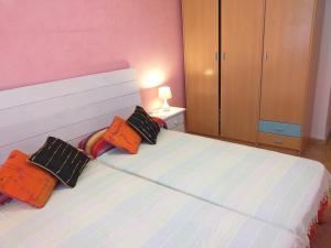 a bedroom with a bed with three pillows on it at Arrecife de las Sirenas in Almería