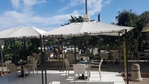 a patio with tables and chairs under umbrellas at B&B Il Porto Vecchio in Stintino