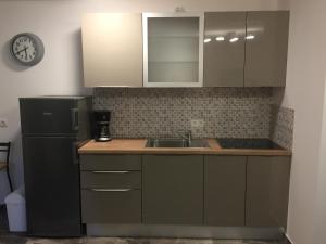 a kitchen with a black refrigerator and a sink at Villa Olea in Punat