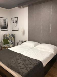 a bedroom with a large bed and a chair at Apartmani ROBERTA in Bol