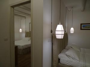 a room with two beds and two lights on the wall at Masseria Bandino & Spa in Otranto