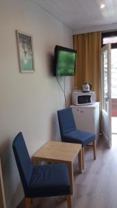 a living room with two chairs and a table and a television at Sea Hotel Mäntyniemi in Siltakylä +38 photos