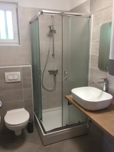 een badkamer met een douche, een toilet en een wastafel bij Villa Olea in Punat