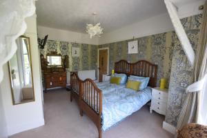 a bedroom with a bed with blue and yellow pillows at Newberry Beach lodge in Combe Martin