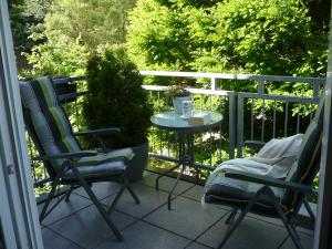 een patio met 2 stoelen en een tafel op een balkon bij Ferienwohnungen Meindl in Idar-Oberstein