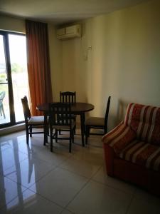 a living room with a table and chairs and a couch at Aparthotel Afrodita 2 in Sinemorets