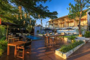 a patio at a hotel with tables and umbrellas at Sala Lanna Chiang Mai in Chiang Mai