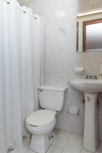 a white bathroom with a toilet and a sink at Hotel Santander Veracruz - Malecon in Veracruz