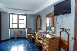 a room with a desk with a mirror and a television at Hotel Santander Veracruz - Malecon in Veracruz