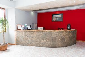 - un bar dans une pièce dotée d'un mur rouge dans l'établissement Hotel Santander Veracruz - Malecon, à Veracruz