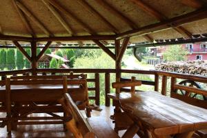 a wooden table and benches in a gazebo at Piscul Muntelui in Moieciu de Sus