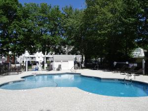 a small swimming pool with chairs and trees at Pink Blossoms Resort in Ogunquit