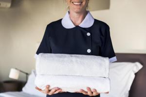 a woman is holding a stack of towels at Fratta5 Luxury Apartment in Verona
