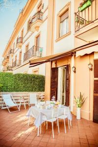 un patio con mesa y sillas frente a un edificio en NEW MOON LUXURY APARTMENT, en Lido di Ostia