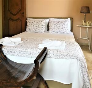 a bedroom with a bed with a chair next to it at Sandy's Home in Kolymvari