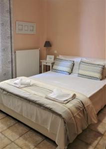 uma grande cama branca com duas toalhas em Sandy's Home em Kolymvari
