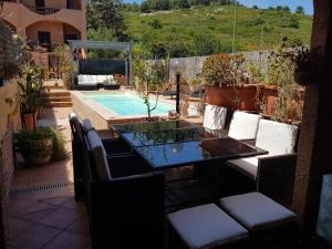 a patio with a table and chairs next to a pool at Casa vacanze Valentina in Porto Conte