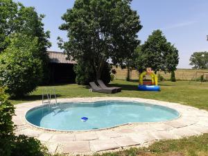 una pequeña piscina en un patio con parque infantil en Rába Part Apartman, en Rábaszentmihály