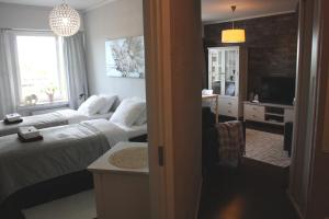 a hotel room with two beds and a television at City Apartment Haapaniemenkatu in Kuopio