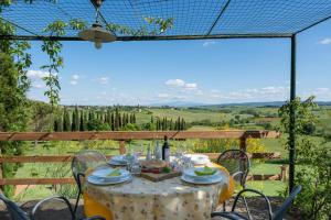 einen Tisch mit einer weißen Tischdecke und Stühlen sowie Aussicht in der Unterkunft Il Palazzetto in Siena