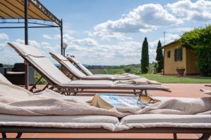 eine Reihe von Liegestühlen auf einer Terrasse in der Unterkunft Il Palazzetto in Siena