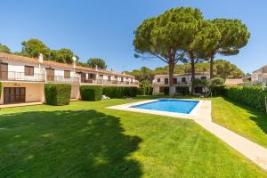 a villa with a swimming pool and a yard at Holiday Home Gardenia in L'Escala