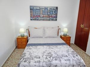 a bedroom with a bed with two night stands and two lamps at ROMA 11 GANDÍA - Alquiler a familias in Gandía +42 photos