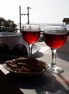 アギオス・ゴルディオスにあるMARGARITAS' ROOMSのワイン2杯、テーブルの上に盛り付けられた料理
