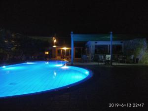 a swimming pool at night with a house at Stamatia Studios in Razáta