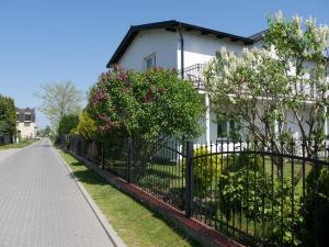 uma cerca preta em frente a uma casa branca em Pokoje gościnne Na Klifie em Jastrzebia Gora