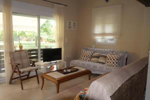 ein Wohnzimmer mit Sofa und Fernseher in der Unterkunft Plane Tree House in Mákri