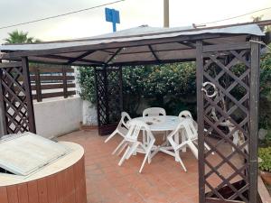 a gazebo with a table and chairs on a patio at Beb Eclissi in Fontane Bianche