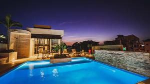 a swimming pool in front of a house at night at Alko Hotel Cotona in Santa Marta