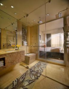 a bathroom with a shower and a tub and a bed at EB Hotel Miami Airport in Miami