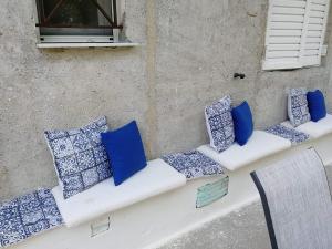 eine Bank mit blauen und weißen Kissen darauf in der Unterkunft Lemontree in Athen