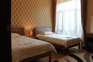 two beds in a small room with a window at Spirit Apartman in Hajd&uacute;szoboszl&oacute;